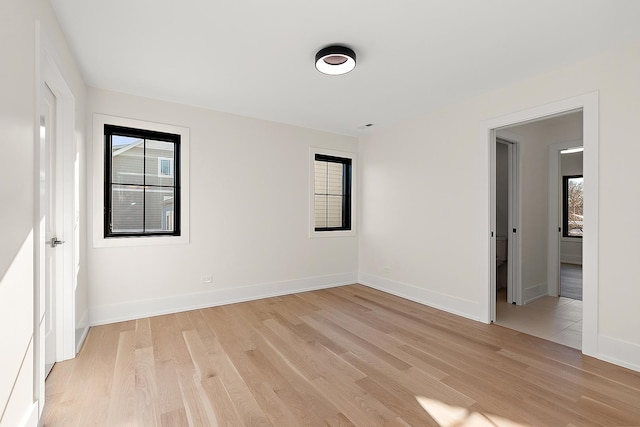 empty room with light wood-type flooring and baseboards