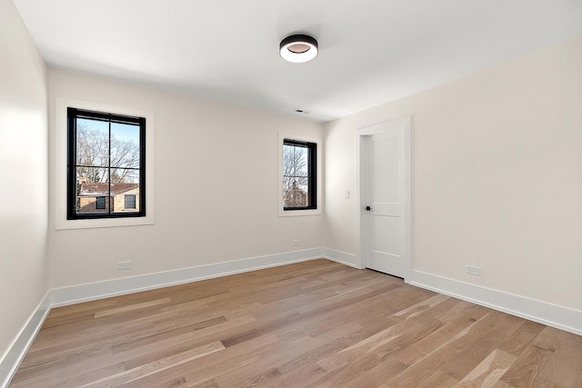 unfurnished room with light wood-type flooring and baseboards