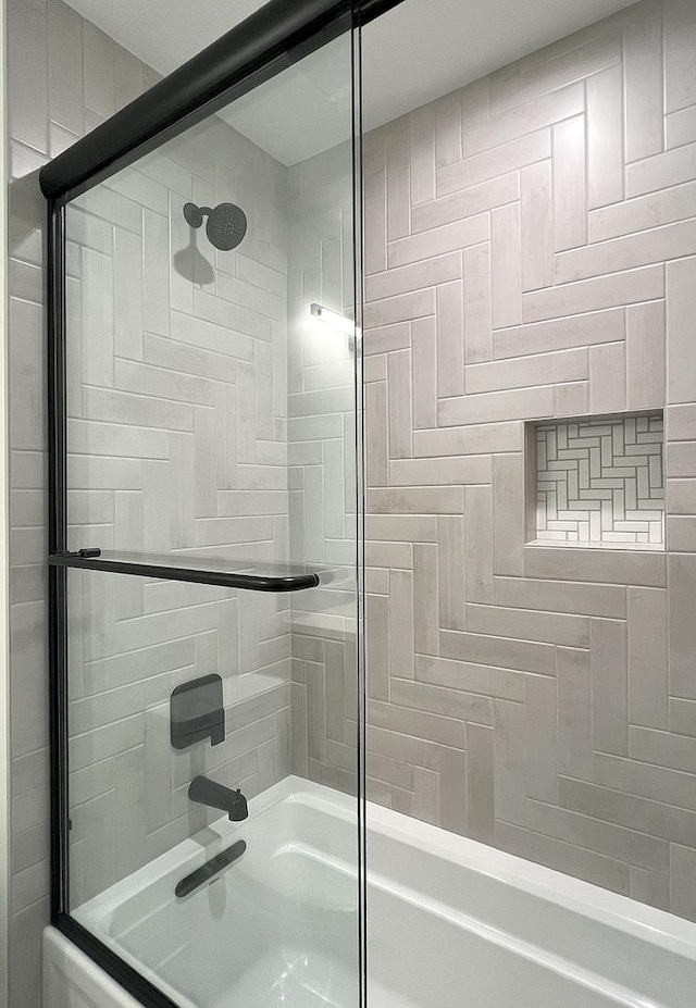 bathroom with combined bath / shower with glass door