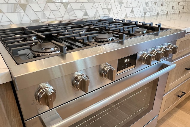 interior details featuring tasteful backsplash and stainless steel range