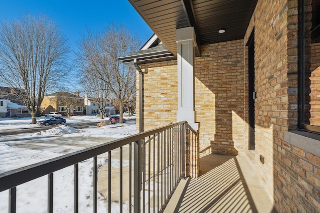 snow covered back of property featuring a residential view