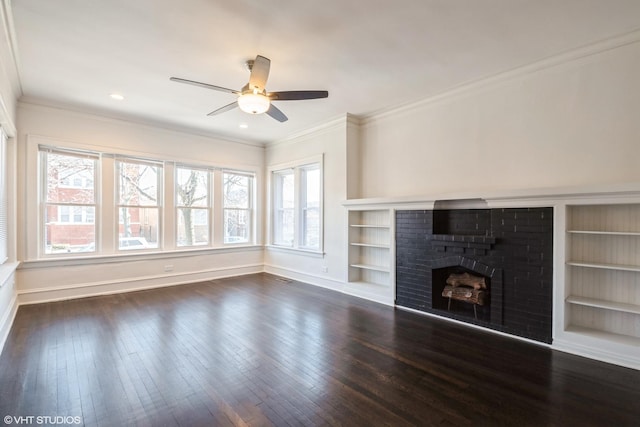 unfurnished living room featuring dark wood-type flooring, built in features, ornamental molding, and a brick fireplace