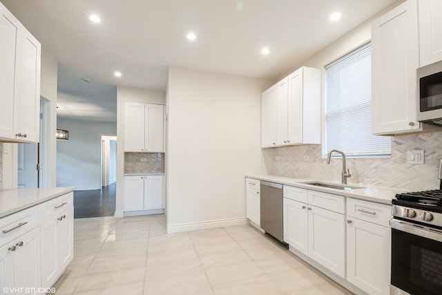 kitchen featuring light tile patterned flooring, sink, white cabinetry, stainless steel appliances, and decorative backsplash