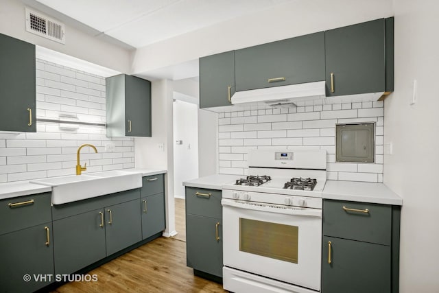 kitchen featuring sink, green cabinets, white range with gas cooktop, light wood-type flooring, and exhaust hood