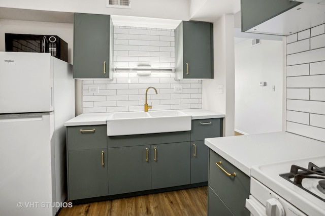 kitchen featuring white appliances, backsplash, dark hardwood / wood-style flooring, and sink