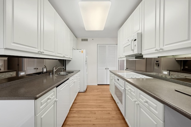 kitchen with white cabinetry, sink, white appliances, and light hardwood / wood-style floors