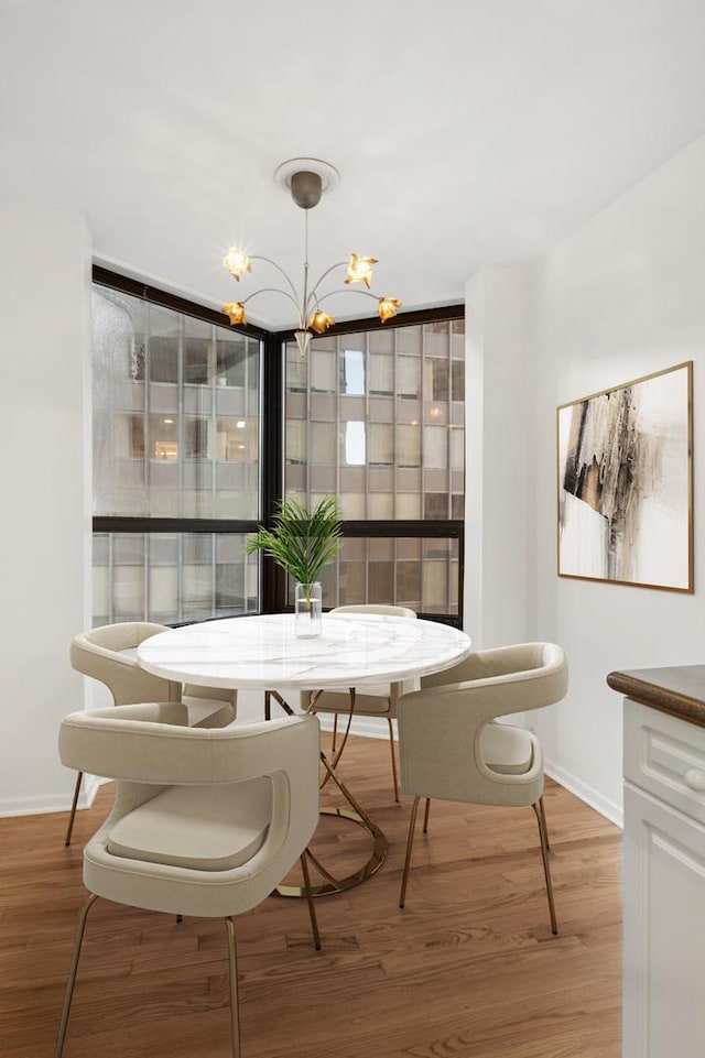 dining space featuring a chandelier, floor to ceiling windows, and light hardwood / wood-style flooring