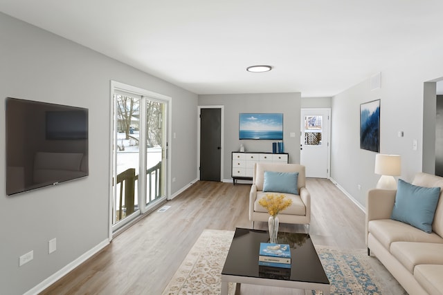 living room with a healthy amount of sunlight and light wood-type flooring