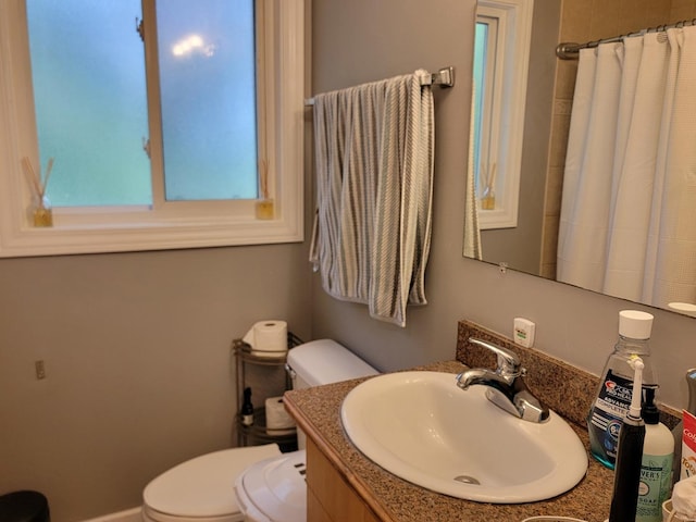 bathroom with toilet, vanity, and a shower with shower curtain