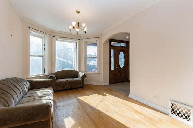 living room with an inviting chandelier, hardwood / wood-style flooring, and crown molding