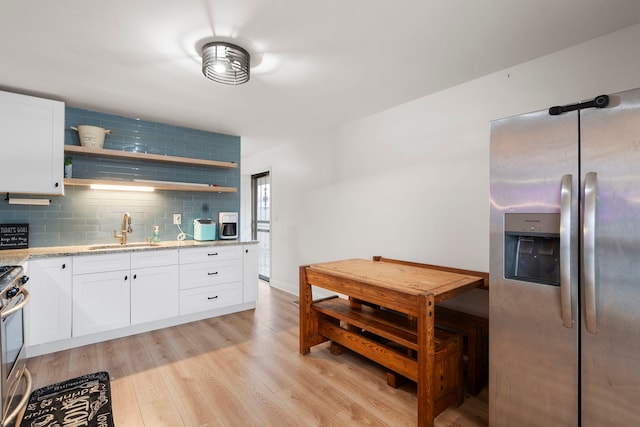 kitchen with white cabinetry, appliances with stainless steel finishes, sink, and light hardwood / wood-style flooring