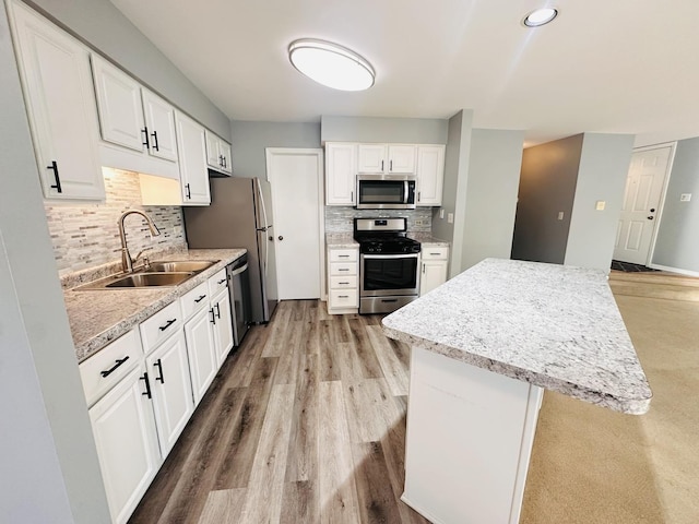 kitchen with sink, white cabinetry, backsplash, and appliances with stainless steel finishes