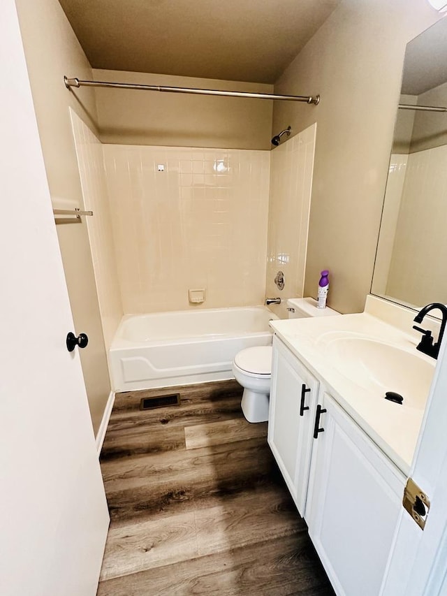 full bathroom with shower / bathing tub combination, wood-type flooring, vanity, and toilet