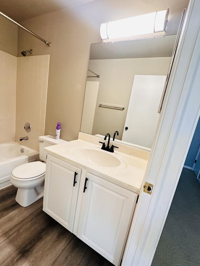 full bathroom with washtub / shower combination, hardwood / wood-style floors, vanity, and toilet