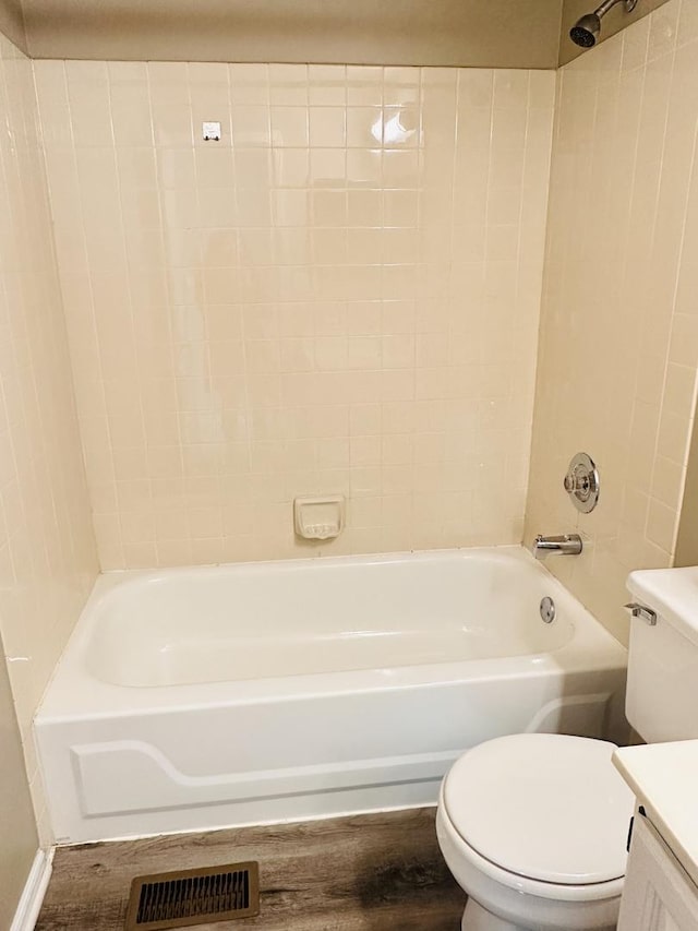 full bathroom featuring wood-type flooring, vanity, toilet, and tiled shower / bath combo