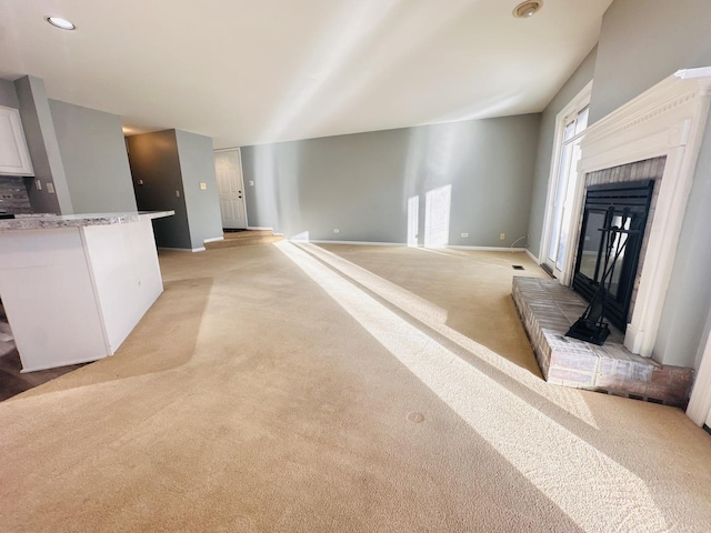 living room featuring light carpet and a brick fireplace