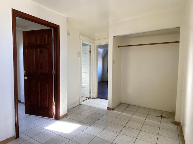 interior space with a closet and light tile patterned floors