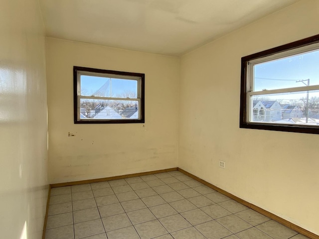 empty room with plenty of natural light and light tile patterned floors