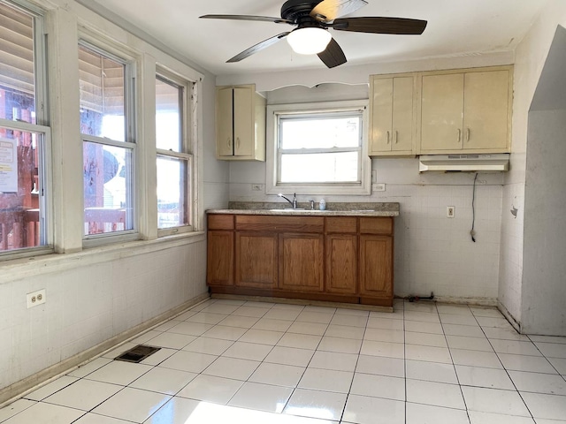 kitchen with ceiling fan and tile walls