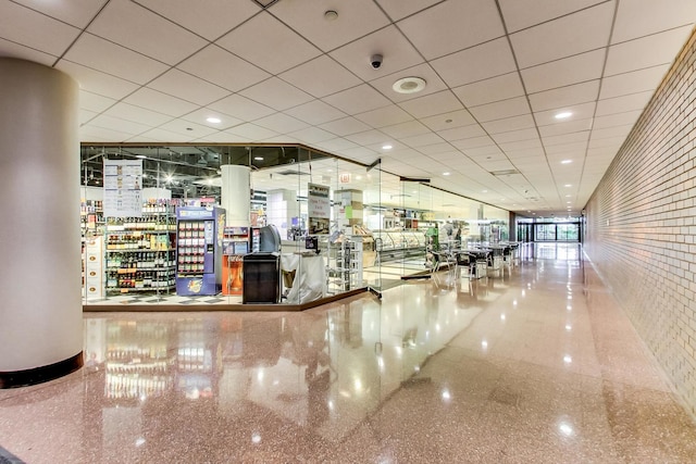 interior space featuring a drop ceiling and granite finish floor