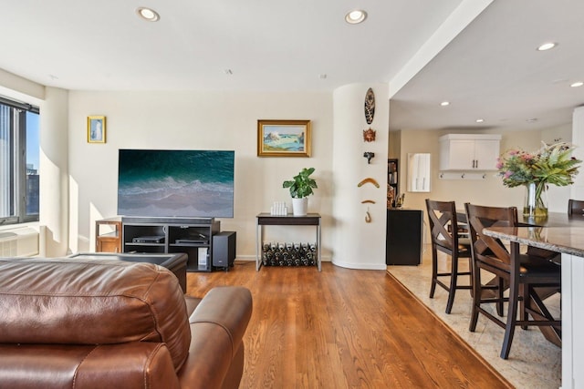 living room featuring light wood-style flooring, baseboards, and recessed lighting