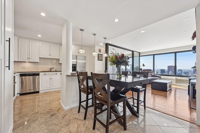 dining room featuring baseboards, recessed lighting, and a city view