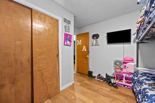 bedroom with wood-type flooring and a textured ceiling