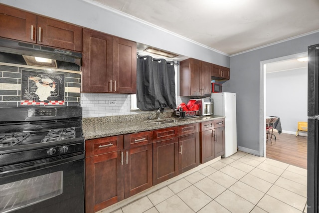 kitchen with tasteful backsplash, black range with gas stovetop, sink, light tile patterned floors, and stone counters