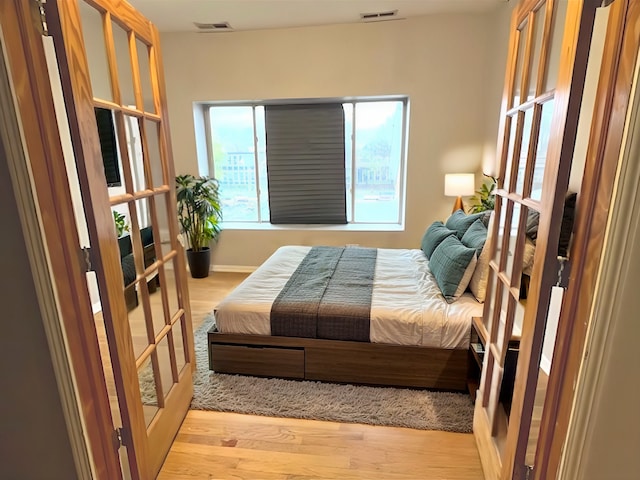 bedroom featuring light hardwood / wood-style floors and french doors