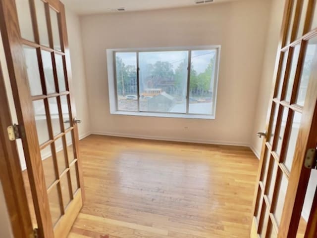 6945 S Dorchester Ave Unit 2S, Chicago, IL 60637 - unfurnished room featuring french doors, light wood finished floors, and baseboards