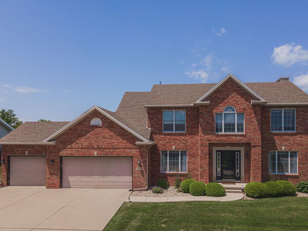 view of front of property featuring a front yard and a garage