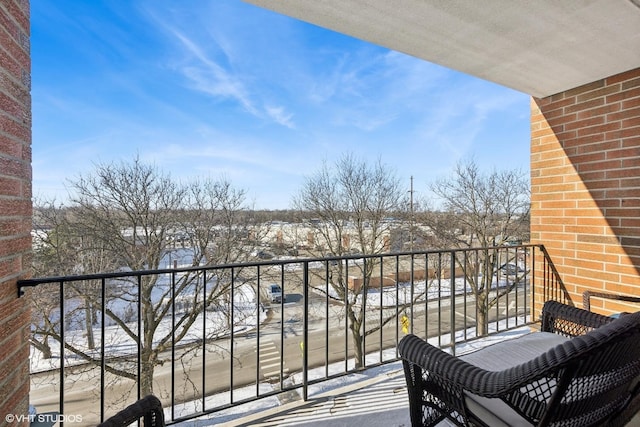 view of snow covered back of property