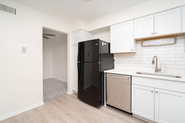 kitchen featuring sink, white cabinetry, dishwasher, and black refrigerator