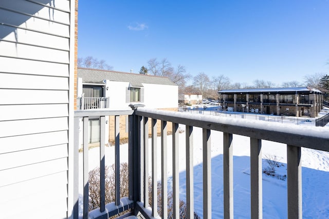 view of snow covered back of property