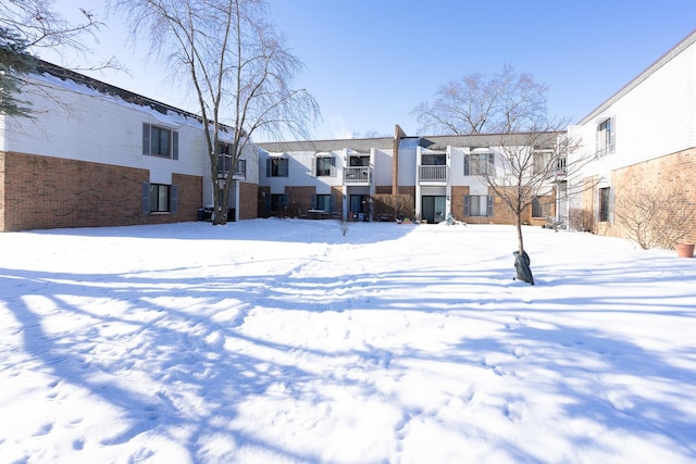 view of snow covered back of property