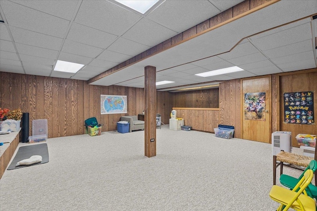 basement with a paneled ceiling and carpet floors