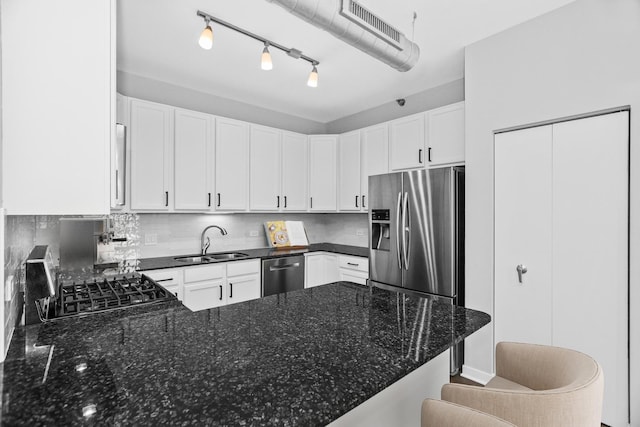 kitchen with a breakfast bar, sink, white cabinetry, kitchen peninsula, and stainless steel appliances