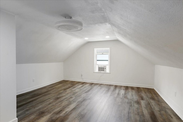 bonus room featuring dark hardwood / wood-style flooring, a textured ceiling, and vaulted ceiling