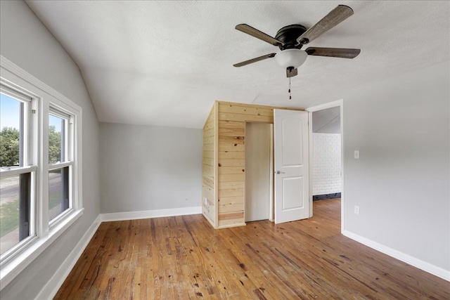 interior space with hardwood / wood-style flooring, ceiling fan, and vaulted ceiling