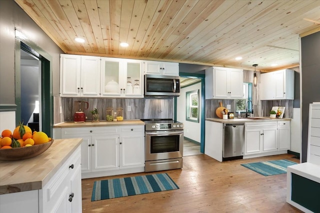 kitchen with wooden ceiling, wooden counters, pendant lighting, white cabinets, and appliances with stainless steel finishes