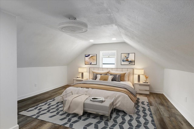 bedroom with a textured ceiling, dark hardwood / wood-style floors, and lofted ceiling