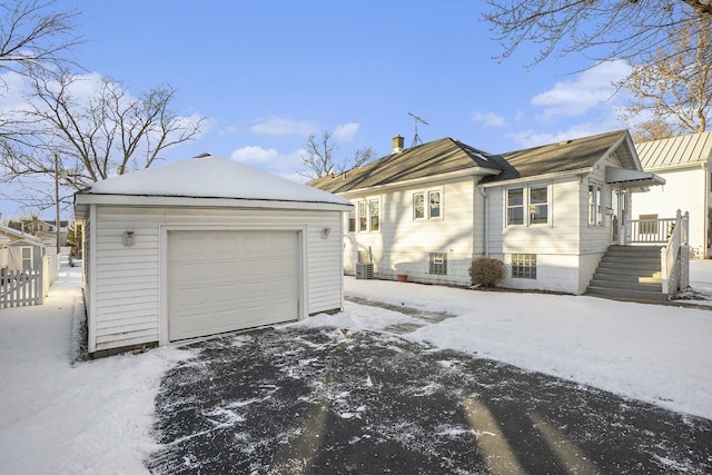 view of snow covered exterior with a garage and an outdoor structure