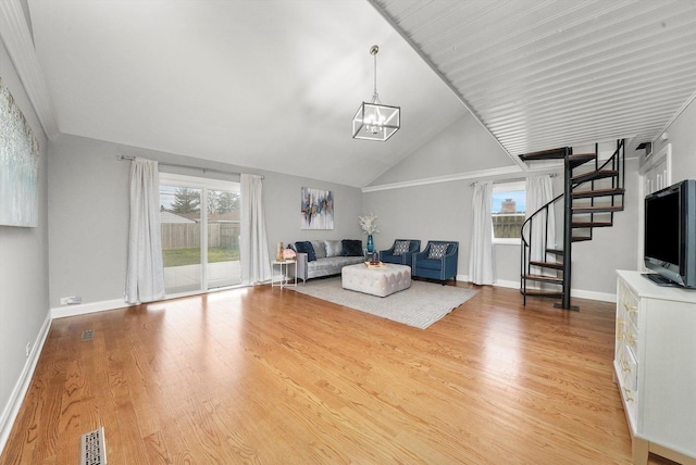 unfurnished living room featuring hardwood / wood-style flooring, lofted ceiling, and a chandelier