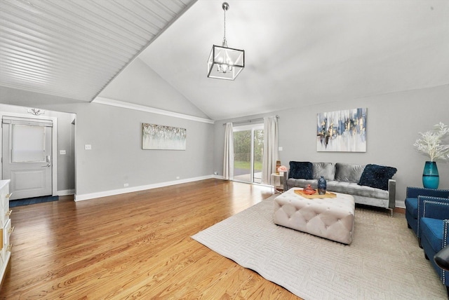 living room featuring light hardwood / wood-style floors, vaulted ceiling, and an inviting chandelier