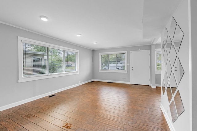 foyer entrance featuring wood-type flooring and crown molding