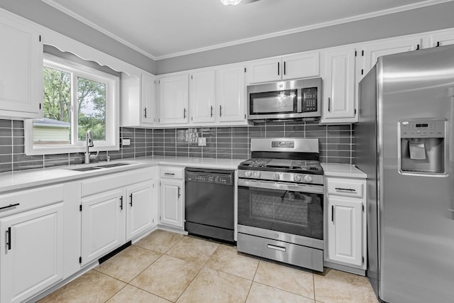 kitchen with ornamental molding, stainless steel appliances, sink, light tile patterned floors, and white cabinets