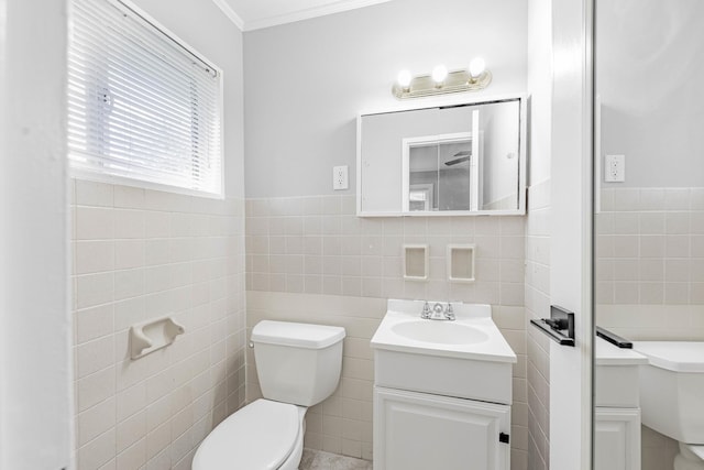 bathroom with vanity, toilet, crown molding, and tile walls