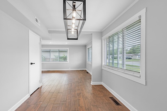 corridor with wood-type flooring and crown molding