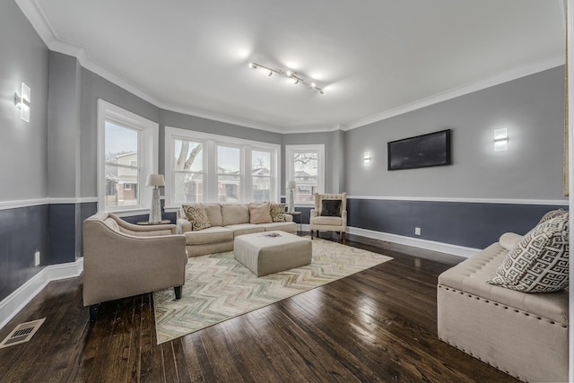 living room featuring ornamental molding, dark wood-type flooring, and track lighting