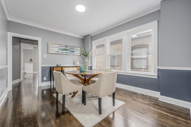 dining room with dark hardwood / wood-style flooring and crown molding